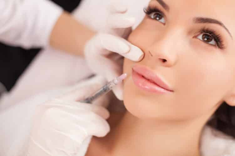 Cheerful healthy lady is visiting expert beautician Dermal fillers