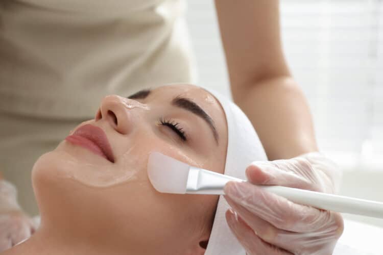 Young woman during face peeling procedure in salon Young woman getting a chemical peel scaled e1657815041792